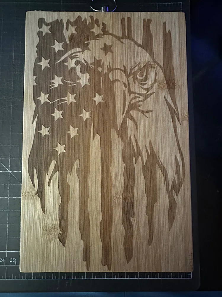 Laser engraving on a cutting board of an American Eagle inside a Decorative American Flag